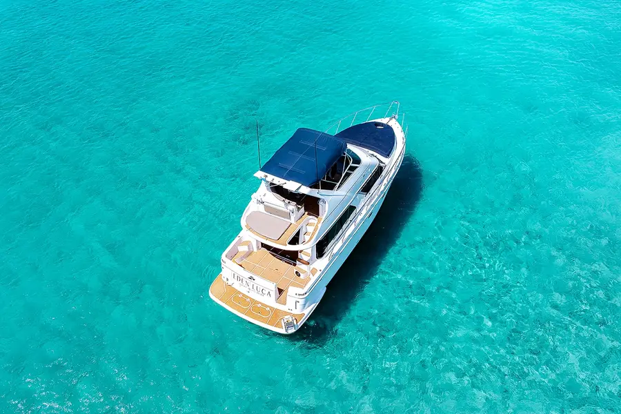 Eden Luca Blue visto de cima em águas turquesa de Aruba, com o solário de proa azul-marinho e o deck de popa em teca