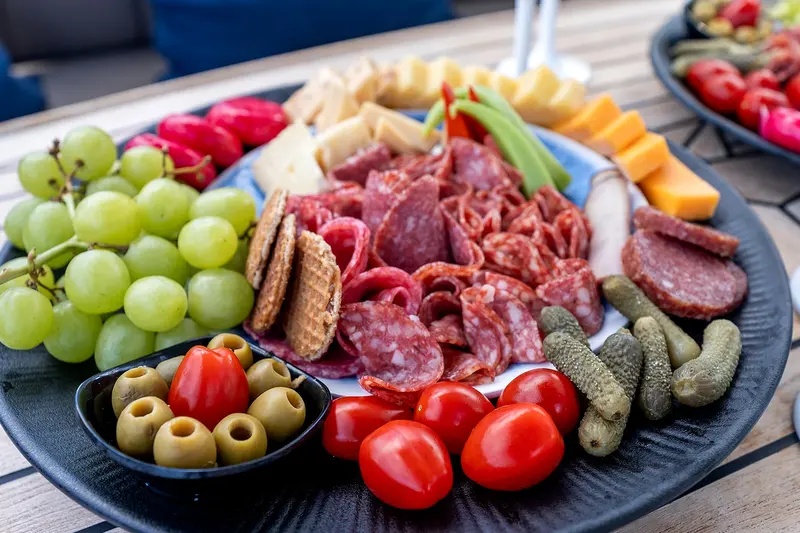 The included charcuterie platter with cheese, olives and fresh fruit, served on board