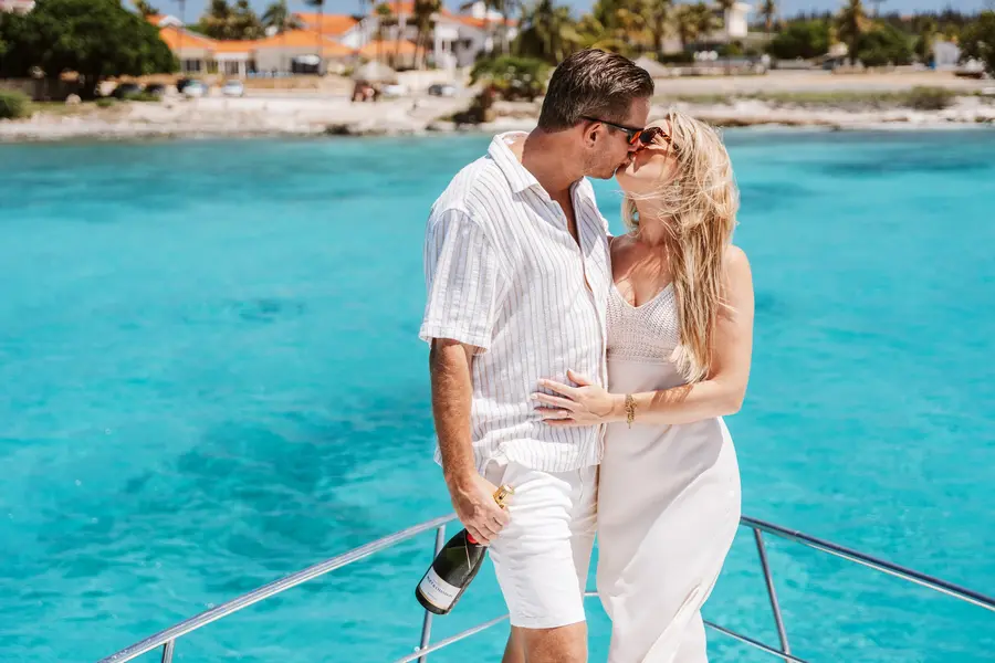 Couple toasting with champagne on the bow of an Eden Luca yacht, VIP Celebration Package