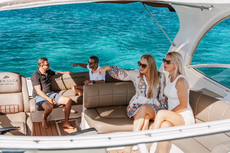 Friends pointing out the view from the cockpit lounge of Eden Luca Red in turquoise water