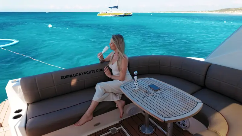 Guest sipping bubbly in the cockpit lounge of Eden Luca Red, turquoise sea all around