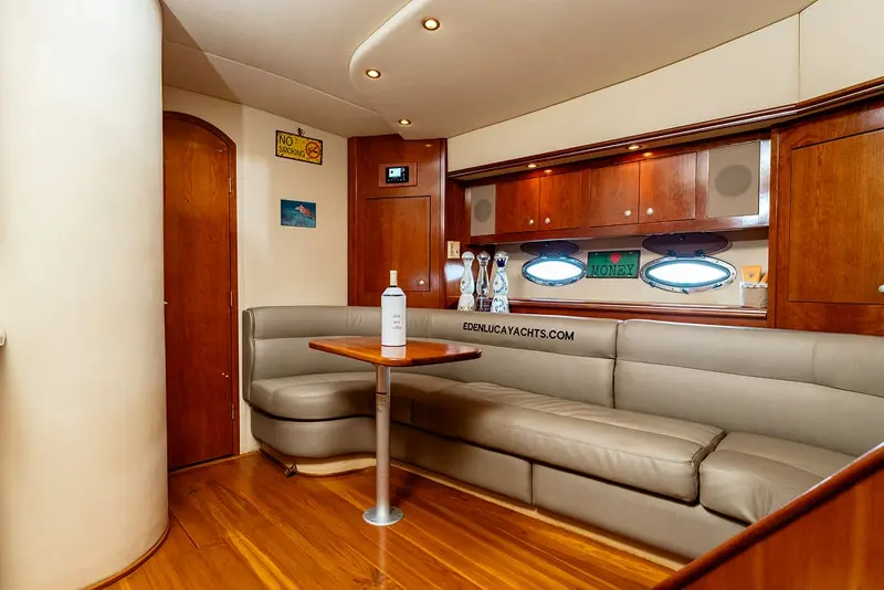 Air-conditioned cabin dinette of Eden Luca Red with a long sofa, table and portholes