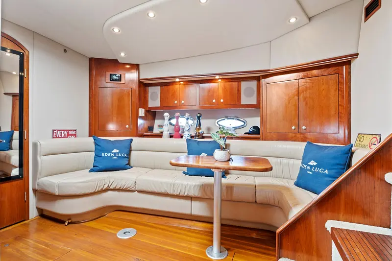 Air-conditioned cabin lounge below deck on Eden Luca Red, cream seating and warm wood