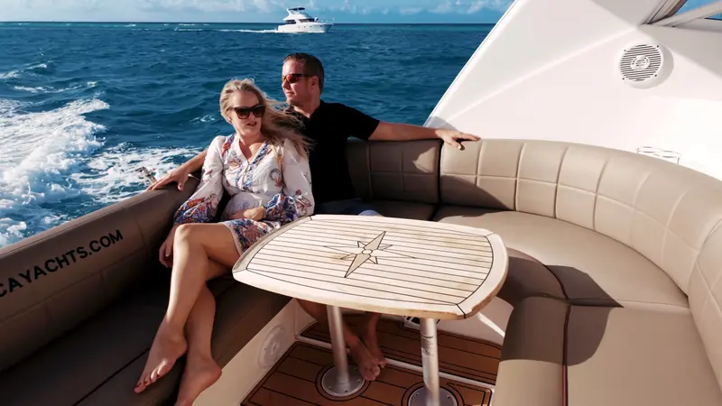 Couple relaxing in the cockpit lounge of Eden Luca Red while Eden Luca Blue cruises behind