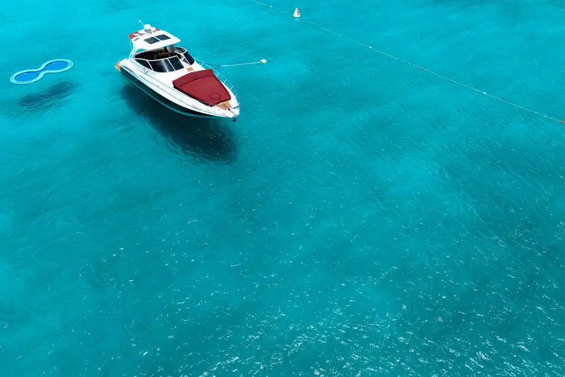 Eden Luca Red from above at anchor, her bordeaux bow lounge bright against turquoise water
