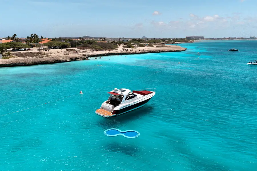 Vista de drone do Eden Luca Red ancorado em águas turquesa intensas no litoral de Aruba