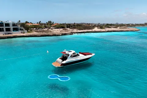 Eden Luca Red ancorado com a boia SunChill, com o litoral de Aruba e as águas rasas turquesa ao fundo