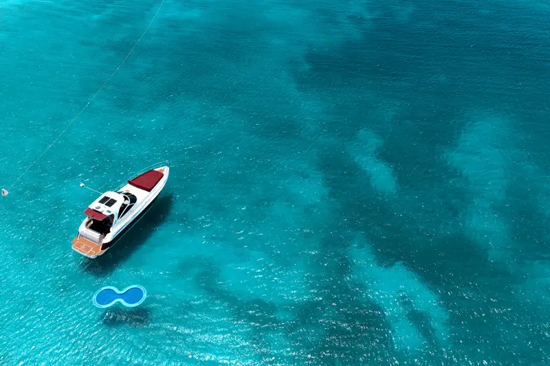 Eden Luca Red seen from above with the SunChill float beside her in clear turquoise water
