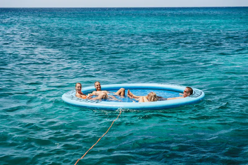 Guests lounging together on the SunChill floating lounge in turquoise water off Aruba