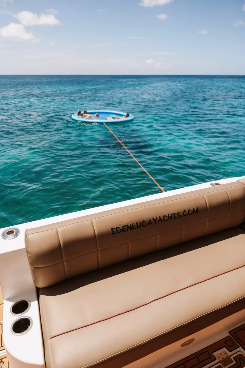 Guests on the SunChill float seen from the stern lounge of Eden Luca Red, clear turquoise water below