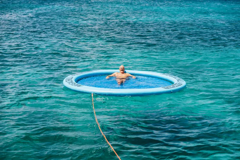 Guest unwinding in the SunChill floating lounge on open turquoise water