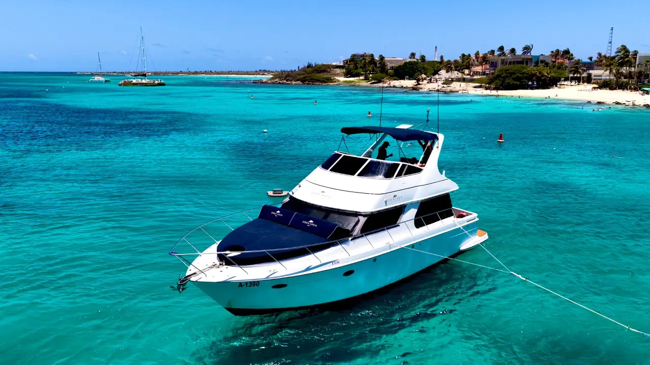 Drone circling Eden Luca Blue at anchor in vivid turquoise water off Aruba