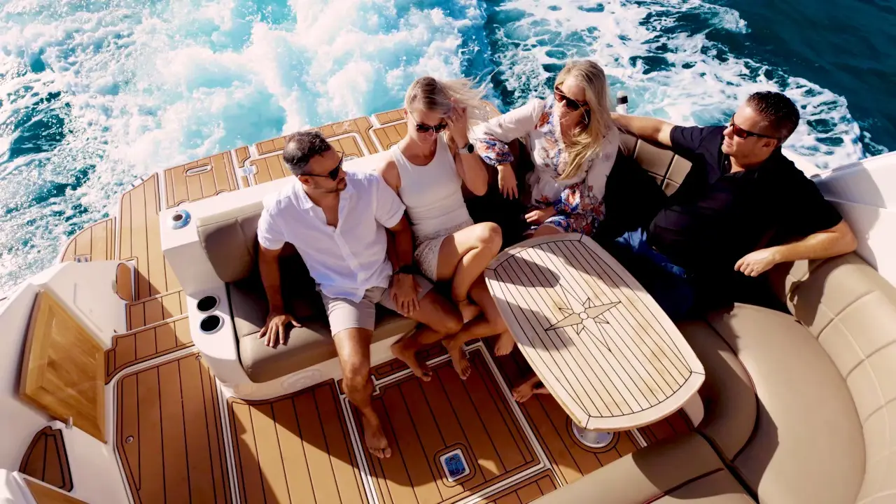 Drone view of two couples cruising in the cockpit of Eden Luca Red over deep blue water