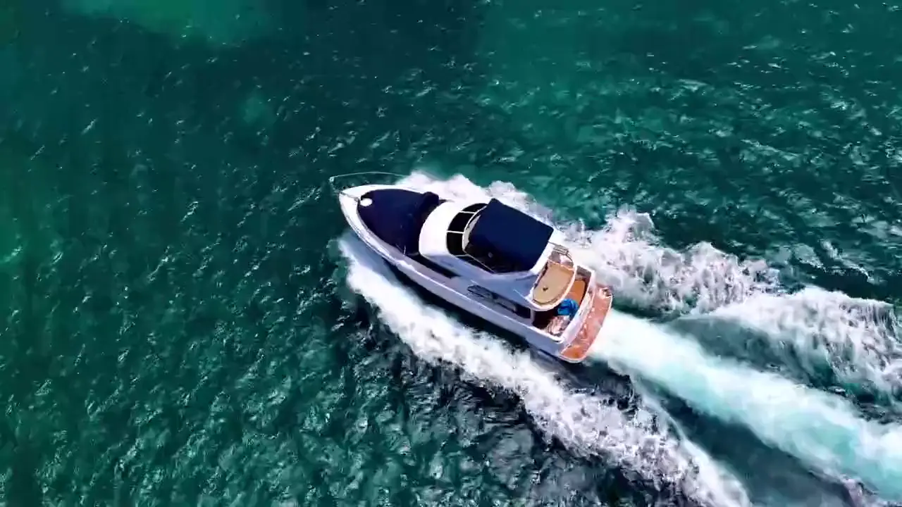 Drone view of Eden Luca Red and Eden Luca Blue cruising Aruba's turquoise water, then guests floating beside Blue