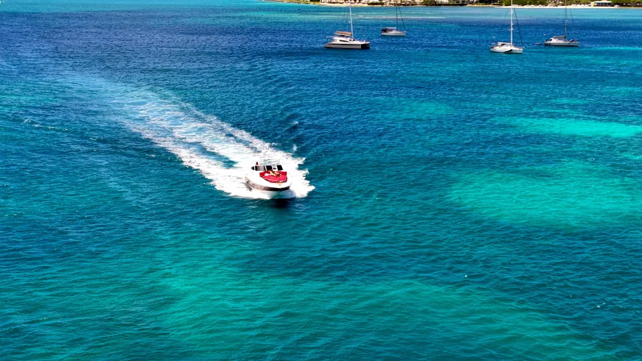 Drone view of Eden Luca Red cruising across deep blue water off Aruba's coast